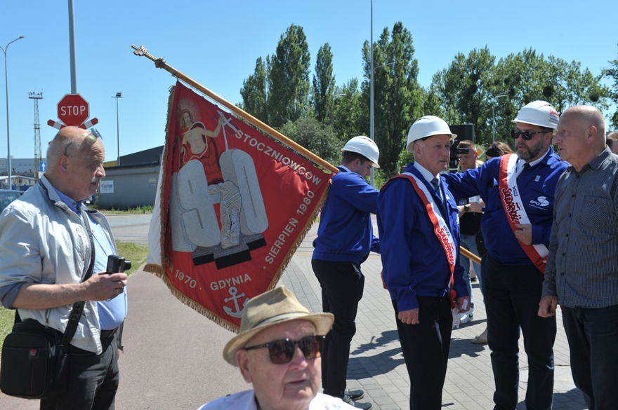 Fotografia przedstawia poczet sztandarowy stoczni uświetniający uroczystość. Po lewej stoi mgr inż. Cezary Kaczmarski Główny Projektant stoczniowego TK - syn widocznego (głowa) Aleksandra Kaczmarskiego.
